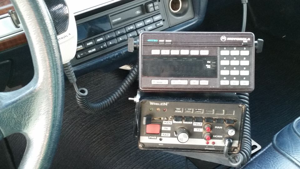 Car interior with Motorola radio and Whelen control box mounted near steering wheel
