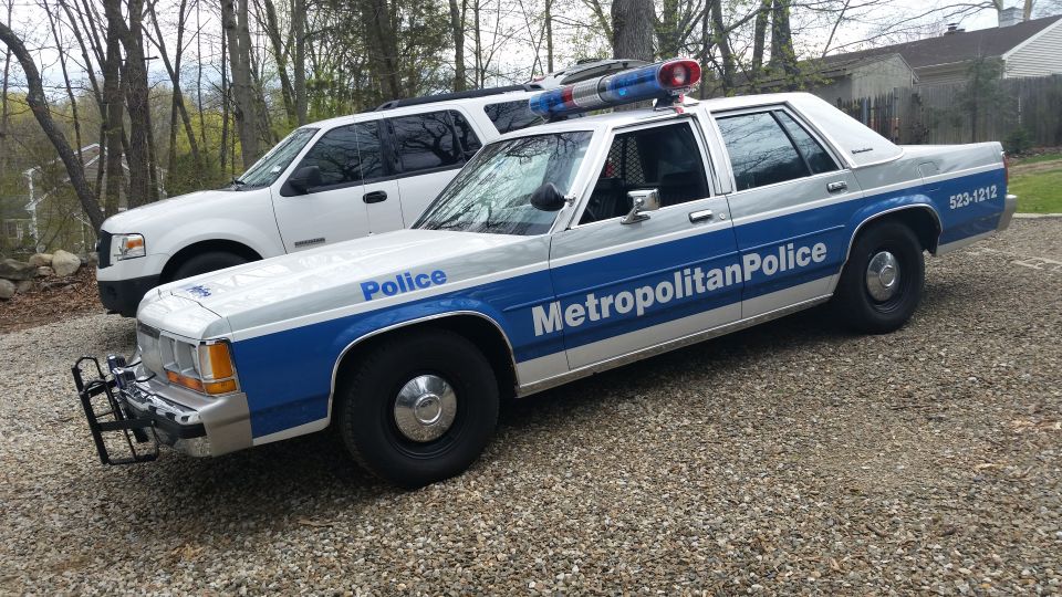 1991 Ford Crown Victoria LTD police car parked next to a white SUV