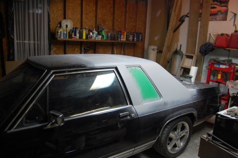 1985 Mercury Grand Marquis - A car in a garage is being prepped for paint, with primer visible on the roof and rear quarter panel.