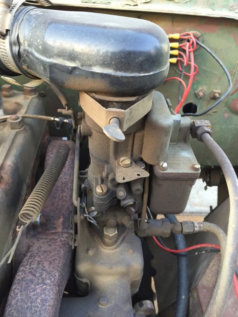 1946 Jeep CJ5 - The engine's carburetor and air intake system are shown in this close-up view, with various hoses and wiring present.