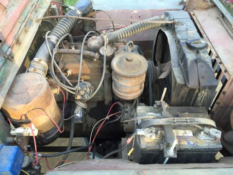 1946 Jeep Willys - The engine compartment of a vehicle, showing the battery, radiator, and engine components.