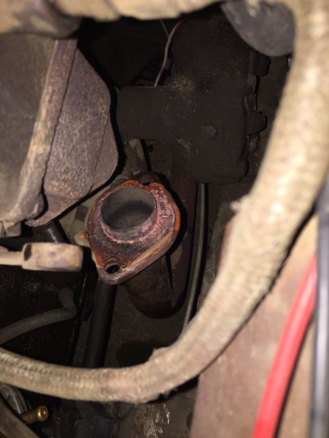 1946 Jeep Willys - Close-up view of a rusty exhaust manifold flange, likely from an older vehicle.