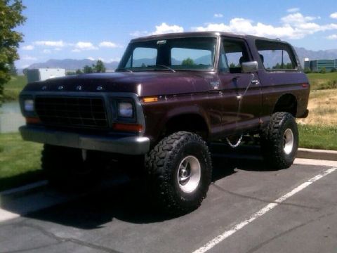 1979 Ford Bronco - This lifted Ford Bronco is parked outside on a sunny day with mountains in the background.