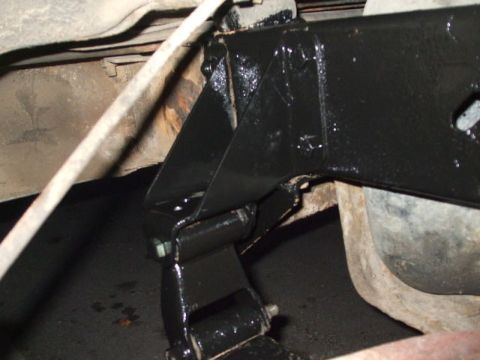 1979 Ford Bronco - Close-up view of vehicle frame and suspension components, showing recent black paint application over rusty areas.