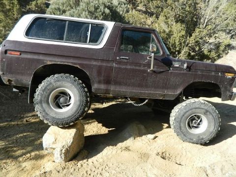 1979 Ford Bronco - This lifted Ford Bronco navigates rocky terrain, demonstrating its off-road capabilities.