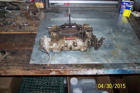 1973 Ford F-250 - Edelbrock carburetor sits on a workbench with various tools and parts around it.