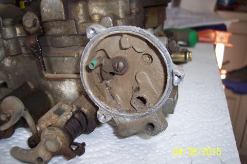 1973 Ford F-250 - Close-up view of a carburetor, showing internal mechanisms and external linkage, likely during a rebuild process.