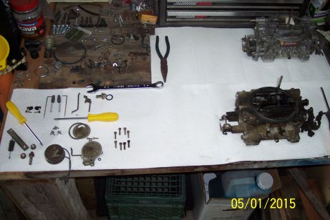 1973 Ford F-250 - Tools and disassembled carburetor components are spread across a paper towel-covered surface.