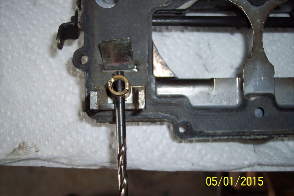 Carburetor gasket with a drill bit inserted into a brass fitting