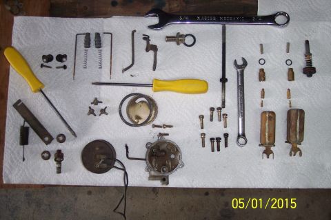 1973 Ford F-250 - Disassembled carburetor parts and tools are arranged on a white cloth for a rebuild.