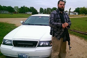 2000 Mercury Grand Marquis - Man with rifle stands next to a white 2000 Mercury Grand Marquis sedan.