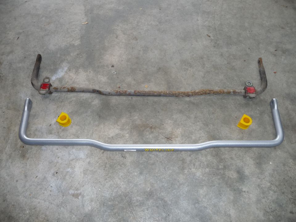 Two sway bars, one rusty and one silver with yellow bushings. Text 'WHITELINE' visible on silver bar