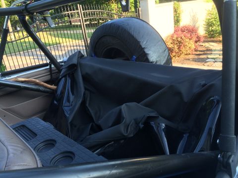 1996 Ford Bronco - Vehicle interior with spare tire and folded soft top visible.