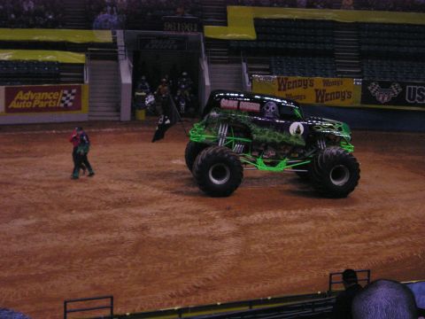 1996 Ford Bronco - A monster truck with "Grave Digger" graphics is shown on a dirt arena floor.