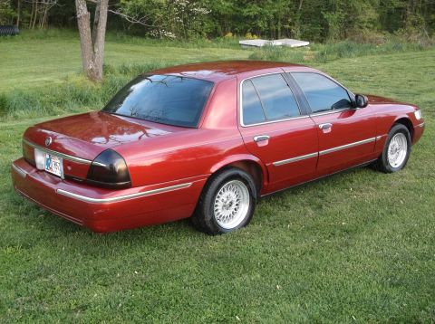 1999 Mercury Grand Marquis - This 1999 Mercury Grand Marquis is shown in a rear three-quarter view, parked on a grassy lawn.