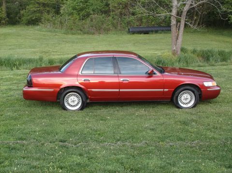 1999 Mercury Grand Marquis - Red 1999 Mercury Grand Marquis sits on a grassy field.
