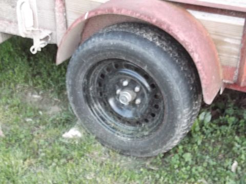 1999 Mercury Grand Marquis - Close-up view of a trailer's wheel and fender, showing signs of wear and rust.