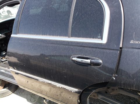 1999 Mercury Grand Marquis - This is a close-up of a car's side door, showing dust and some interior components.