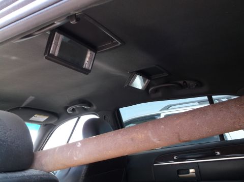 1999 Mercury Grand Marquis - The interior of a 1999 Mercury Grand Marquis shows overhead screens and a large pipe extending through the cabin.