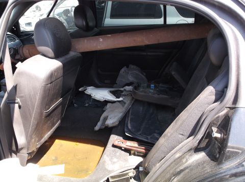 1999 Mercury Grand Marquis - Car interior cluttered with parts and a large pipe across the seats.