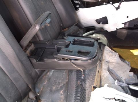 1999 Mercury Grand Marquis - The interior of a vehicle shows an open center console with exposed wiring and worn seats.