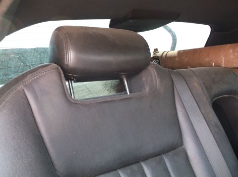 1999 Mercury Grand Marquis - Interior view of a car's rear seat and headrest, with a seatbelt and items in the background.