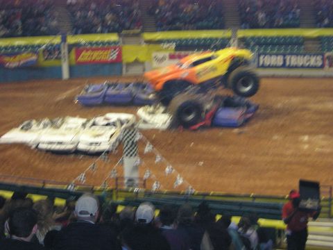 1996 Ford Bronco - Monster truck event with multiple cars being crushed. A Ford Trucks banner is visible in the background.
