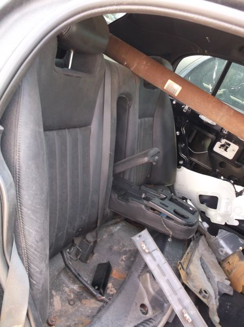 1999 Mercury Grand Marquis - The interior of a car shows the back seats and a large pipe extending across the cabin, with parts of the door panel removed.