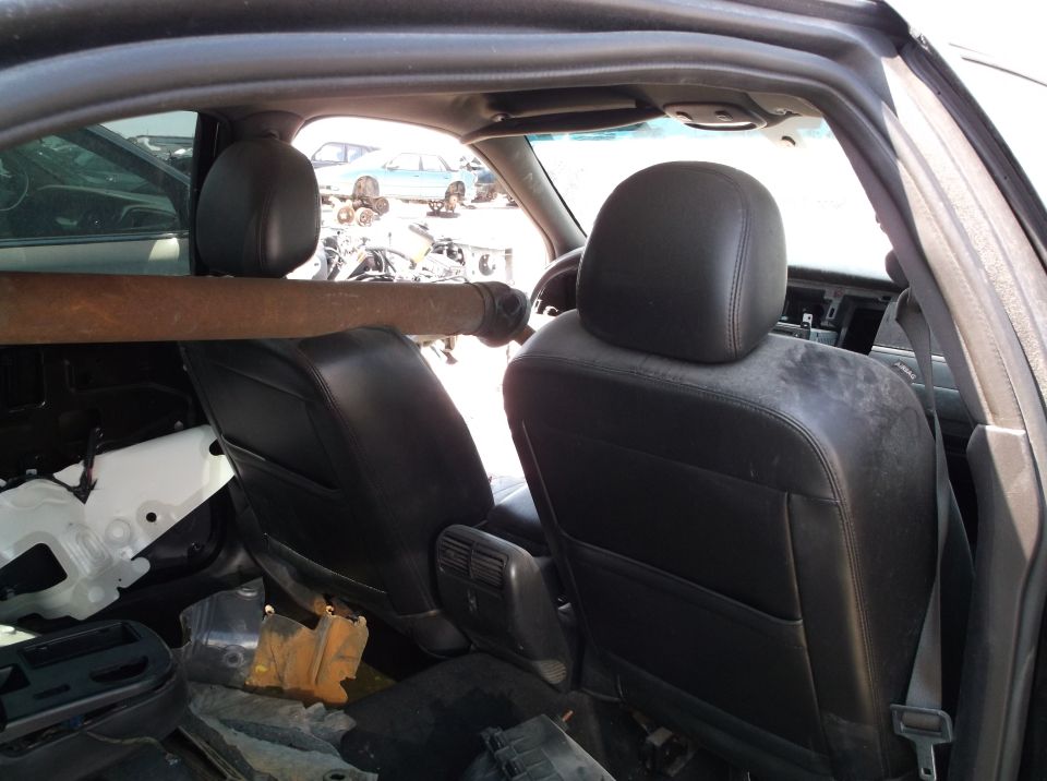 Interior view of a 1999 Mercury Grand Marquis showing the front seats and a driveshaft resting across them