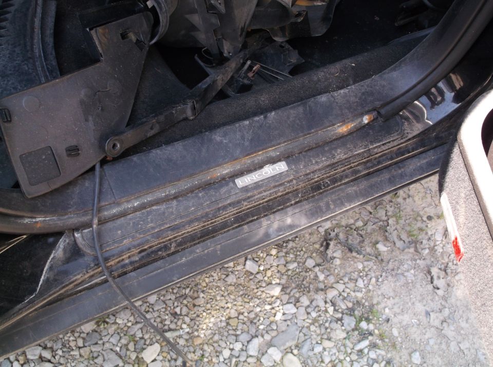 Close-up of a Lincoln door sill plate, showing some rust and dirt