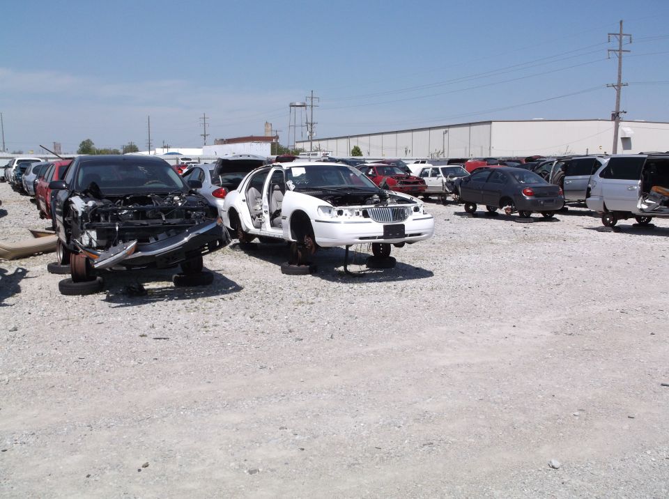 1999 Mercury Grand Marquis in junkyard, front view, hood open, doors open, missing wheels