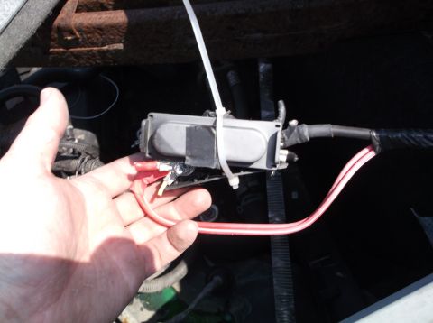 1999 Mercury Grand Marquis - Close-up of an electrical component with red wires being held.