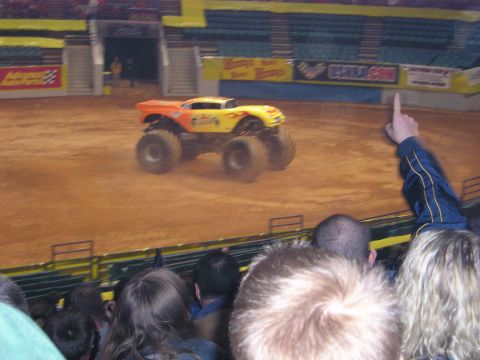 1996 Ford Bronco - A monster truck performs in an arena with spectators watching.
