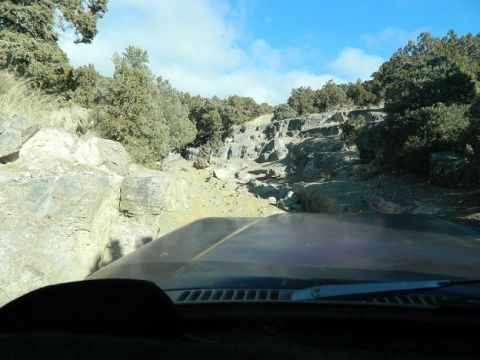 1979 Ford Bronco - Driving an off-road vehicle through a challenging rocky landscape under a partly cloudy sky.