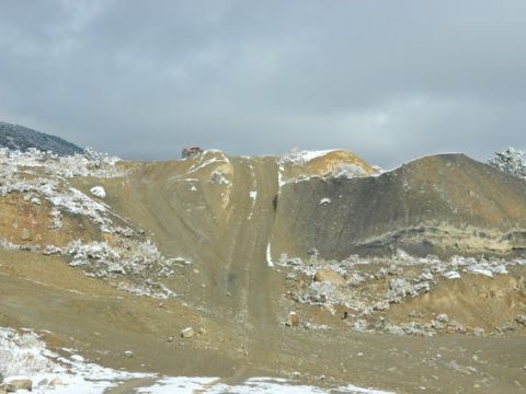 1979 Ford Bronco - A truck is visible on a dirt hill with snow patches under a gray sky.