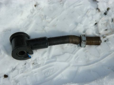 1979 Ford Bronco - A single automotive suspension component rests on a snowy surface.