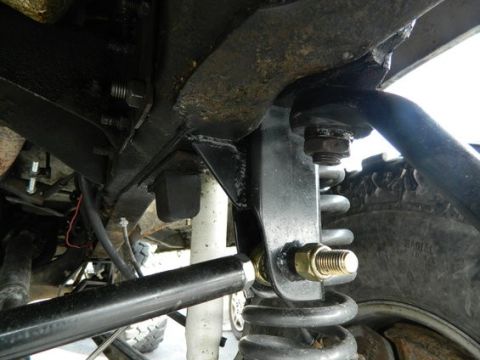 1979 Ford Bronco - Underside view of a vehicle's suspension system, showing the coil spring and shock absorber assembly.