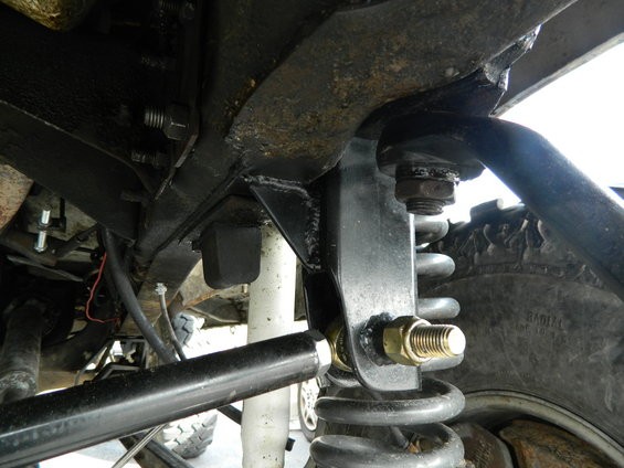 Close-up of vehicle's front suspension with coil spring and shock absorber