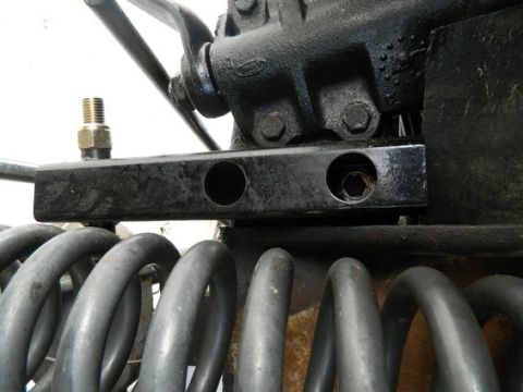 1979 Ford Bronco - Close-up of suspension components, including a metal bracket and coil springs.