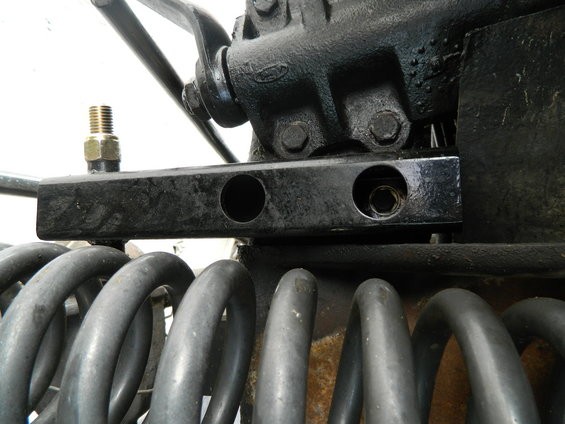 Black metal bracket with bolt holes above grey coil springs