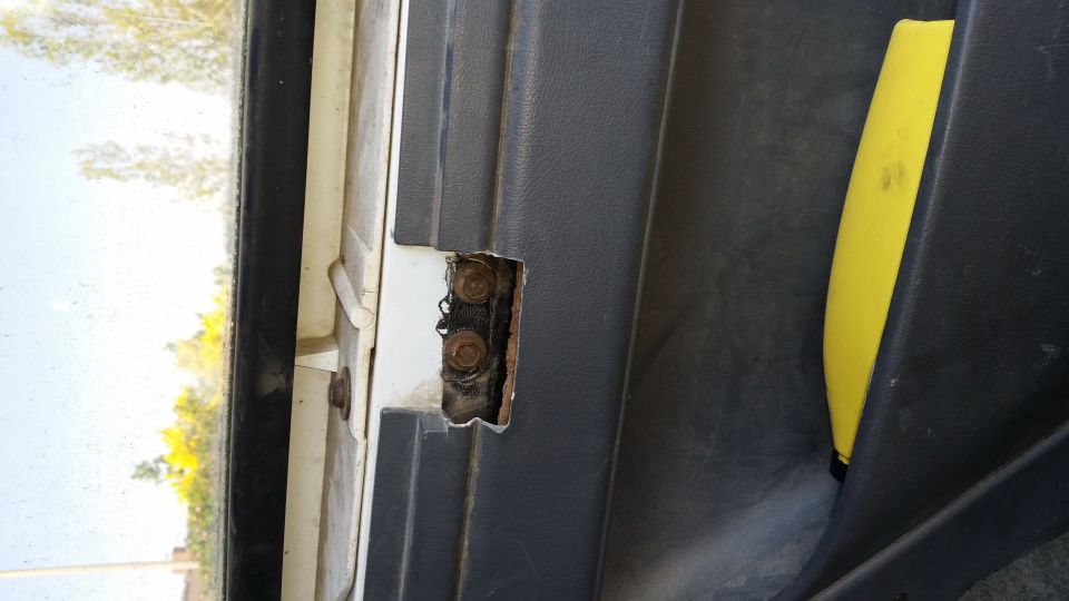 Door hinge with visible bolts and yellow interior trim piece