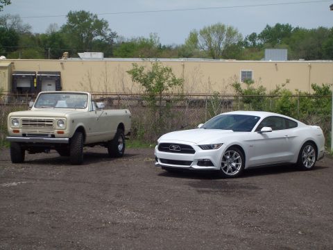 2004 Ford Crown Victoria - Two distinct vehicles, an older Scout and a modern Mustang, are parked side-by-side outdoors.