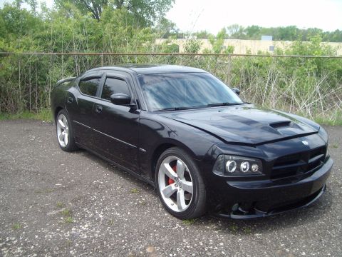 2004 Ford Crown Victoria - A black Dodge Charger is parked outdoors with its hood ajar, revealing a custom hood scoop.