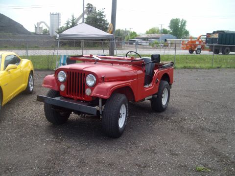 2004 Ford Crown Victoria - A red Jeep CJ is parked next to a yellow Chevrolet Camaro in an outdoor lot.