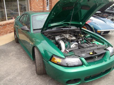 2004 Ford Crown Victoria - This green 2004 Ford Mustang features a modified engine with a prominent turbocharger visible under the open hood.