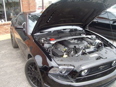 2004 Ford Crown Victoria - Black Ford Mustang with its hood open, revealing the engine bay and front end details.
