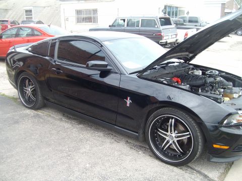 2004 Ford Crown Victoria - Black Ford Mustang with hood open, parked next to a red car.