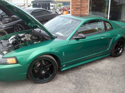 2004 Ford Crown Victoria - A green coupe is parked outside with its hood open, revealing the engine bay.