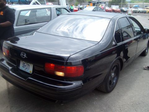 2004 Ford Crown Victoria - A black sedan is parked outdoors with other vehicles visible in the background.