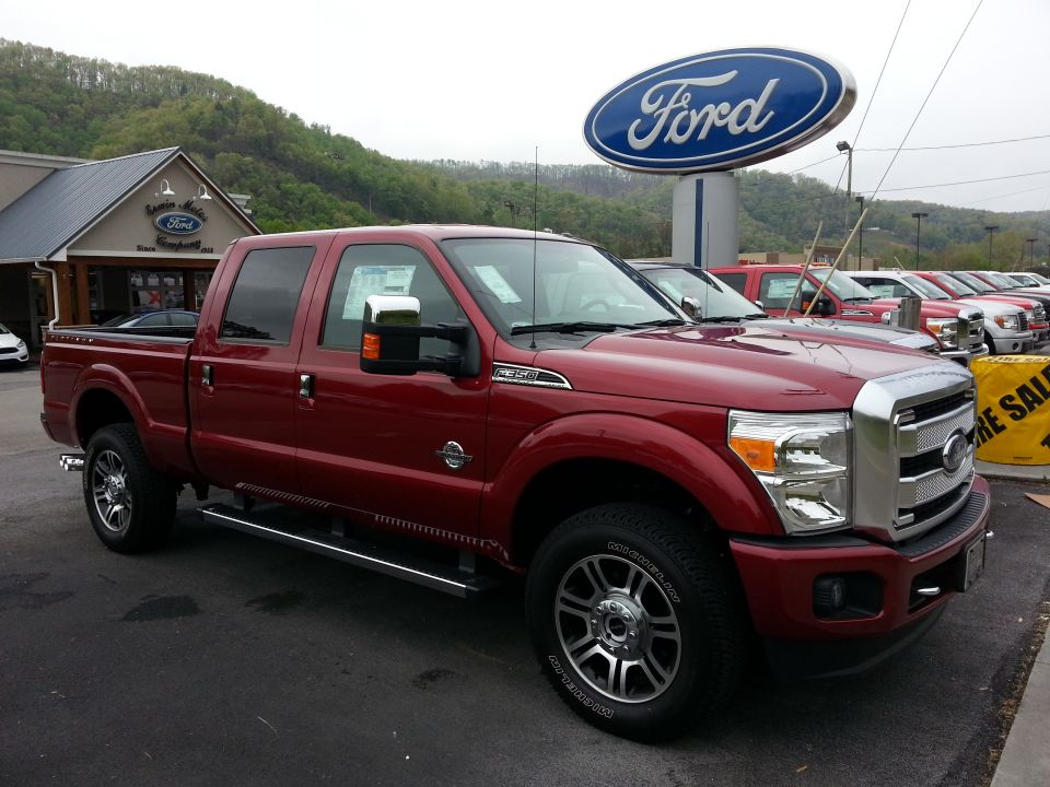Red 2015 Ford F-350 pickup truck parked at a dealership lot